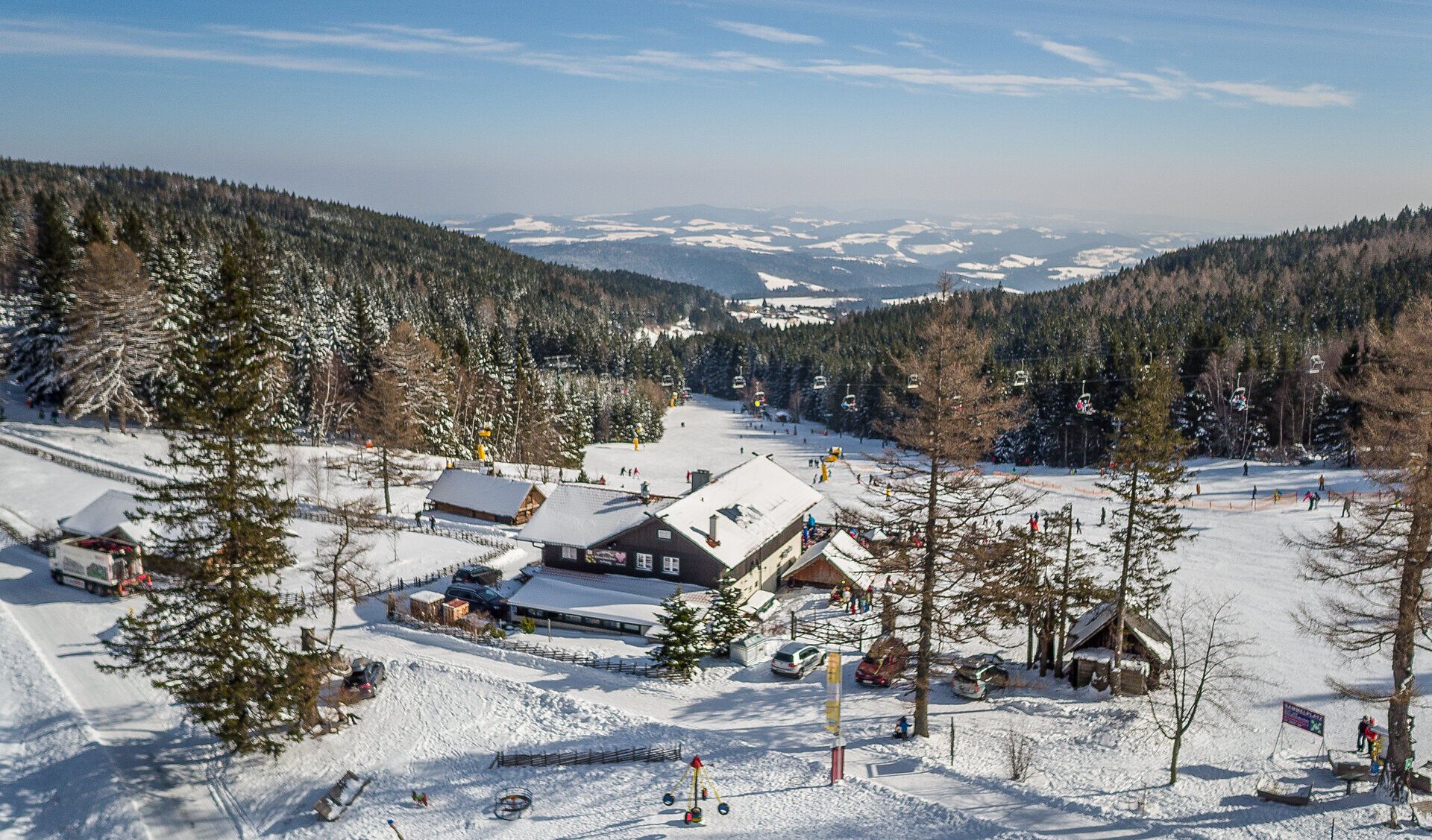 Die verschneite Landschaft lädt zu unvergesslichen Winterabenteuern ein. Gemütliche Hütten und die glitzernde Schneedecke schaffen eine einladende Atmosphäre für Skifahrer und Wanderer. Hier, umgeben von majestätischen Bäumen, wird der Winter zum Erlebnis.