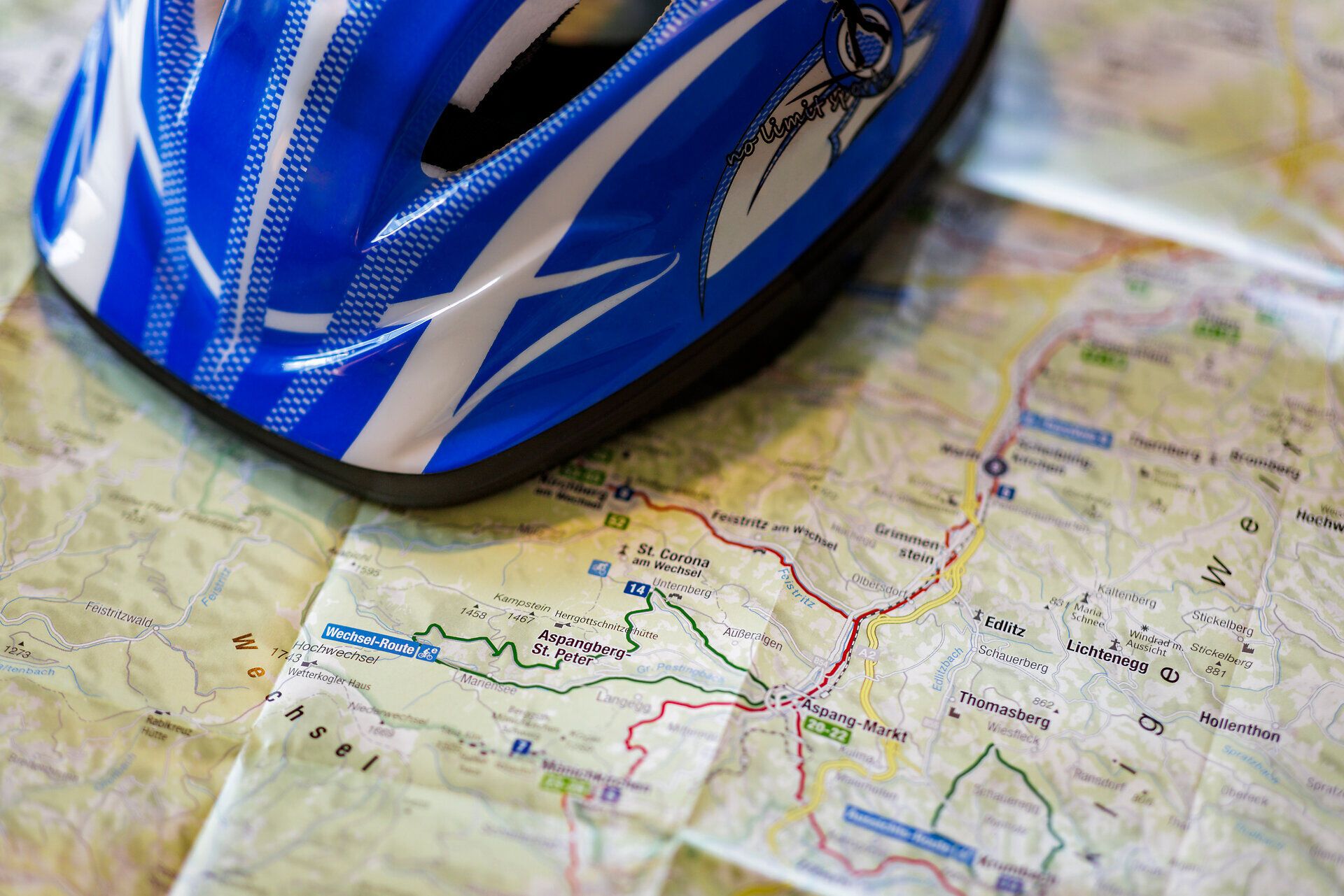 Ein Radhelm liegt auf einer Radkarte, auf der mehrere Radrouten um den Alpengasthof Enzian zu sehen sind.