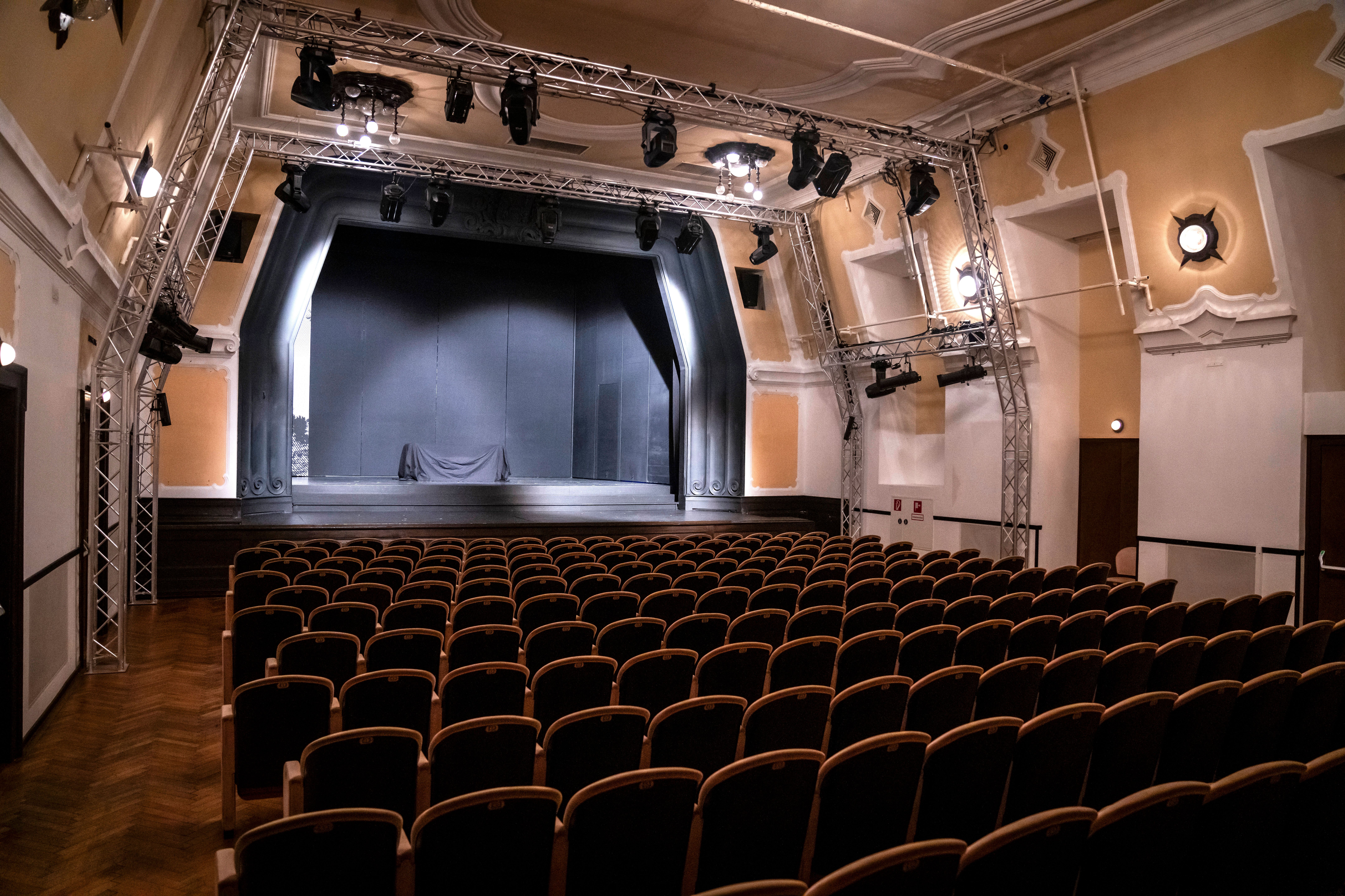 Ein beeindruckendes Theater mit einer einladenden Atmosphäre erwartet die Besucher. Die leeren Reihen der Sitzplätze laden dazu ein, sich auf unvergessliche Aufführungen zu freuen, während das sanfte Licht die Bühne in ein warmes Glühen taucht.