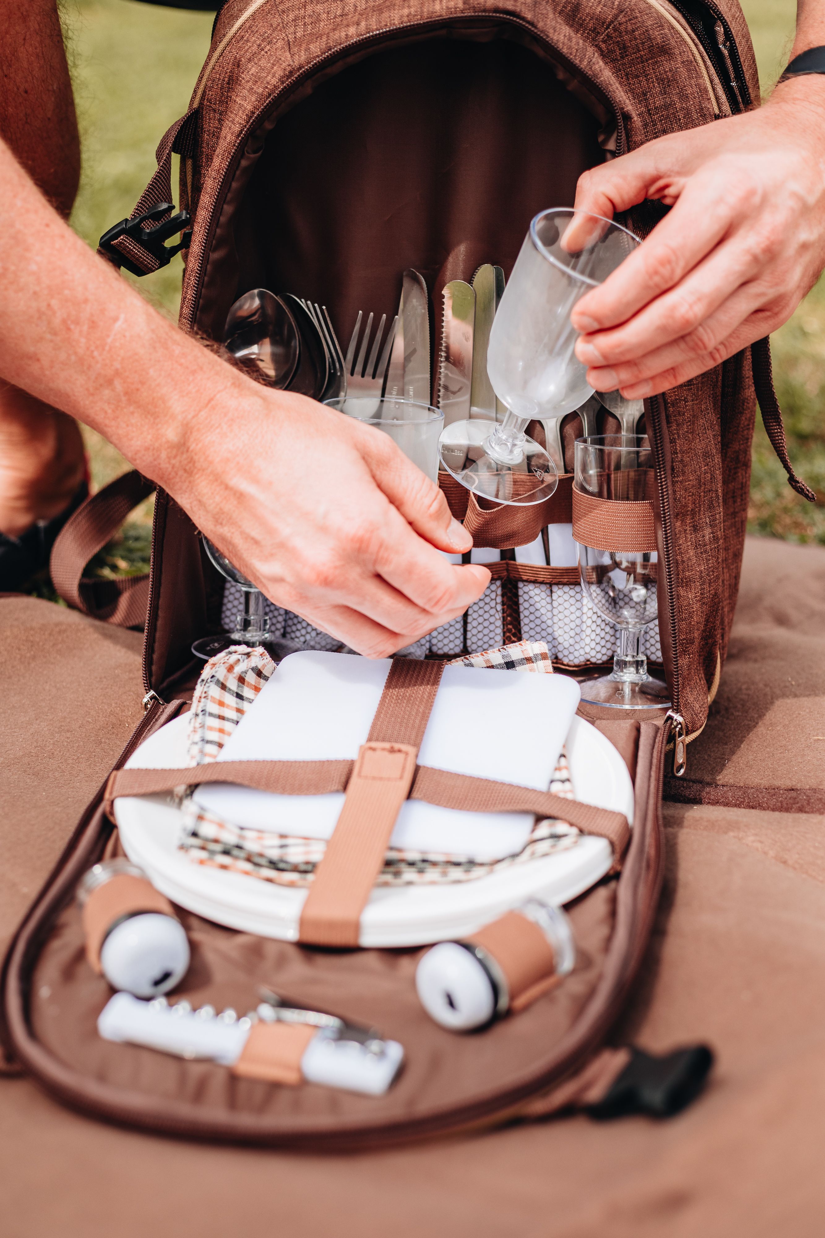 Rucksack gefüllt mit Teller, Gläser und Besteck 