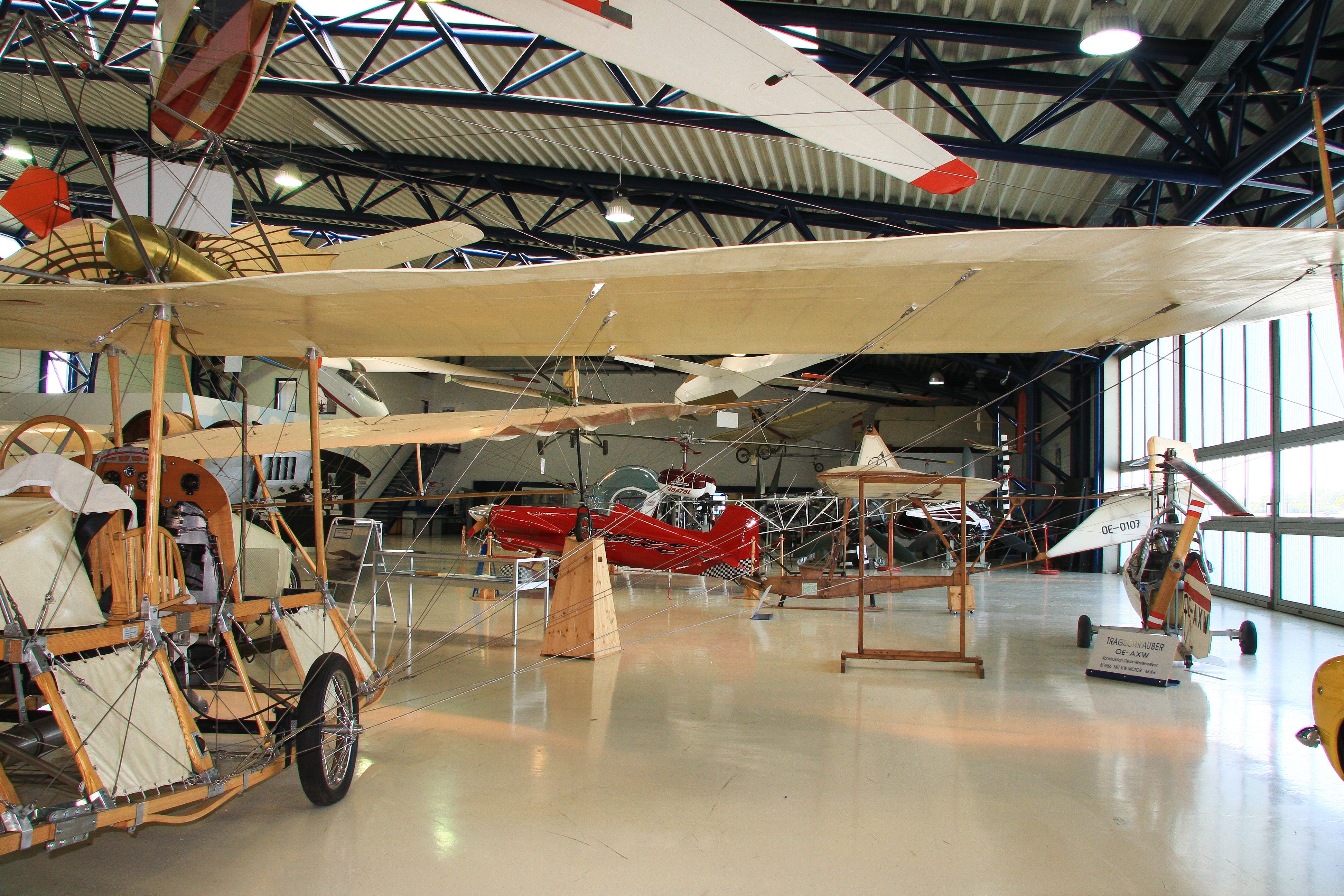 Innenansicht eines Flugmuseums mit historischen Flugzeugen und Segelflugzeugen.