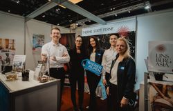 Fünf Personen vor dem Messestand Linsberg Asia 