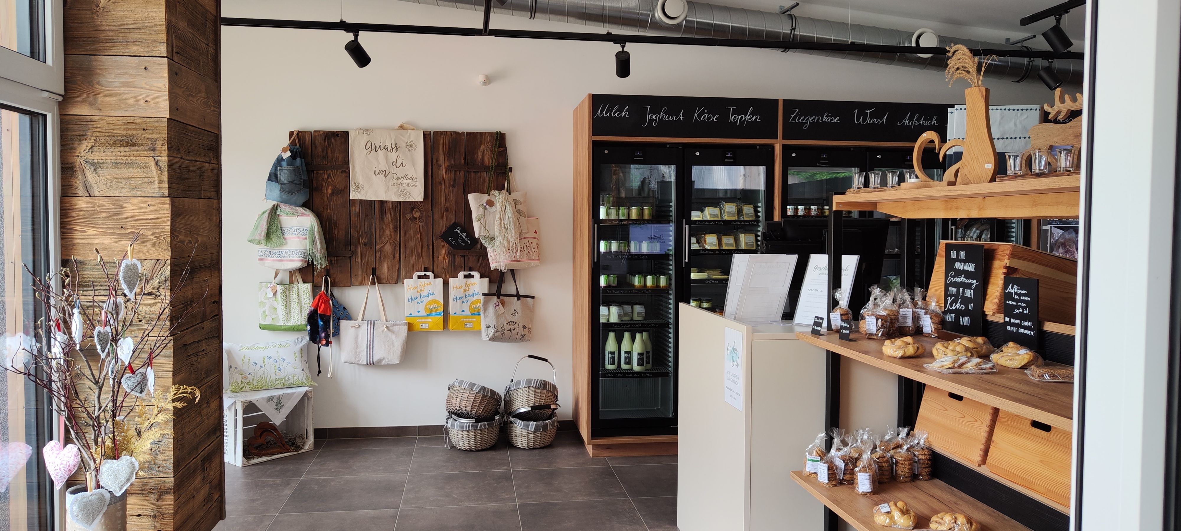 Innenansicht eines Dorfladens mit Regalen voller Produkte und Dekorationen.