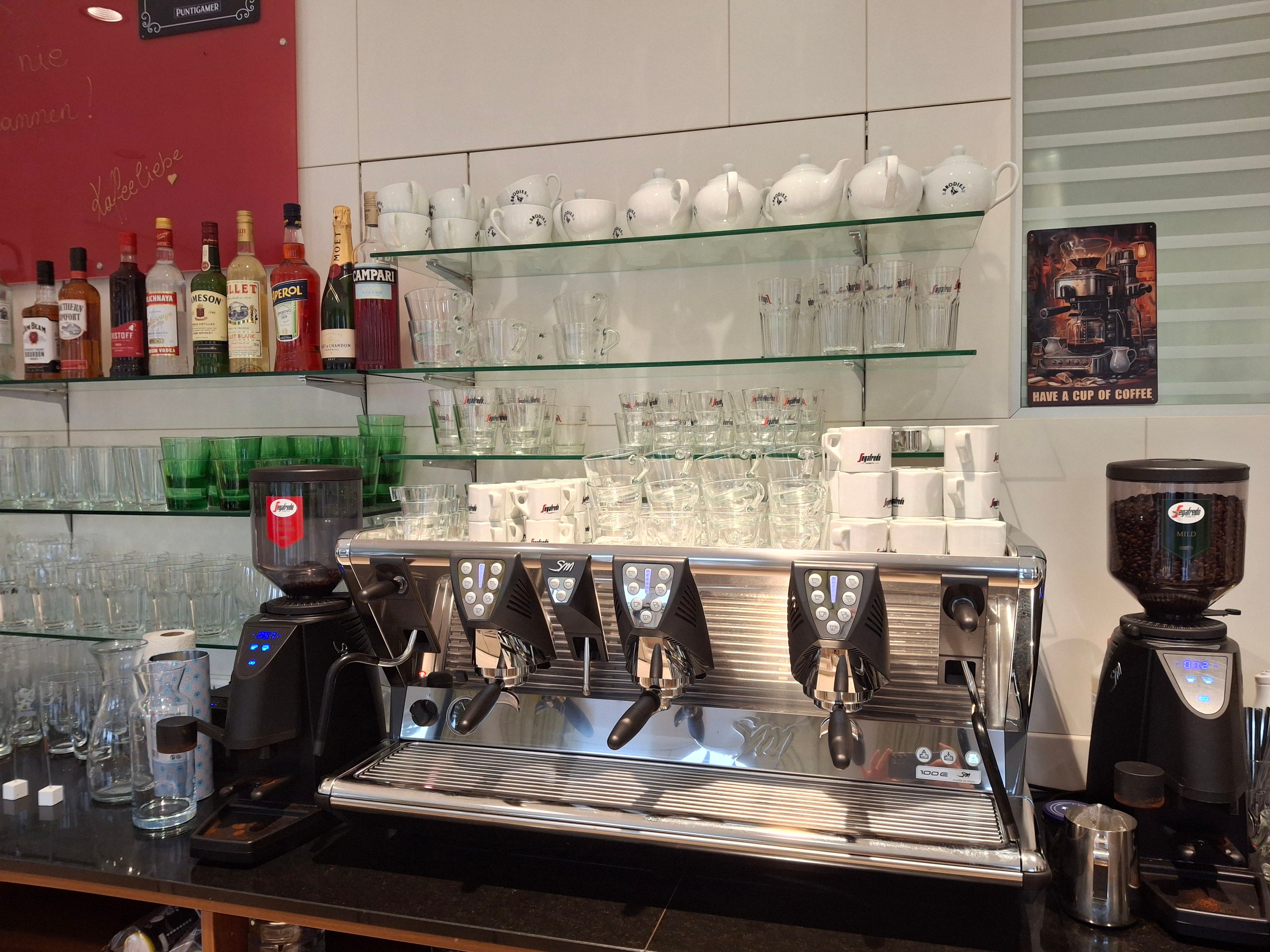 Kaffeemaschine mit Tassen und Gläsern in einem Café.