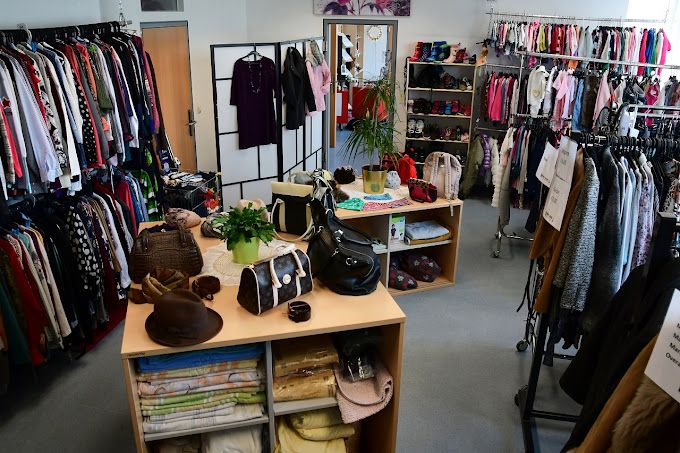 Innenansicht eines Second-Hand-Ladens mit Kleidung und Accessoires.