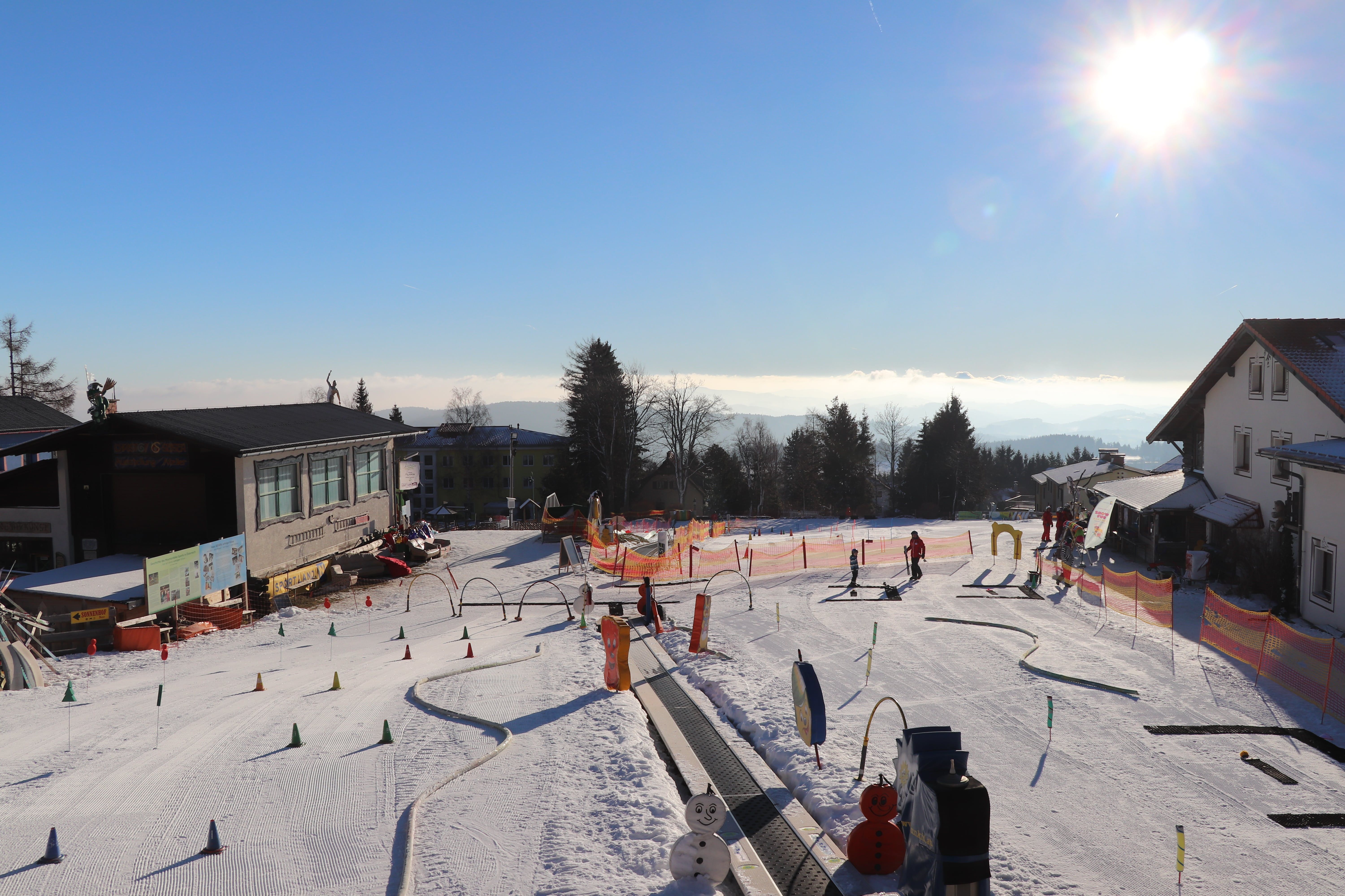 Skischule in Mönichkirchen mit Kindern auf der Piste und Sonnenschein.