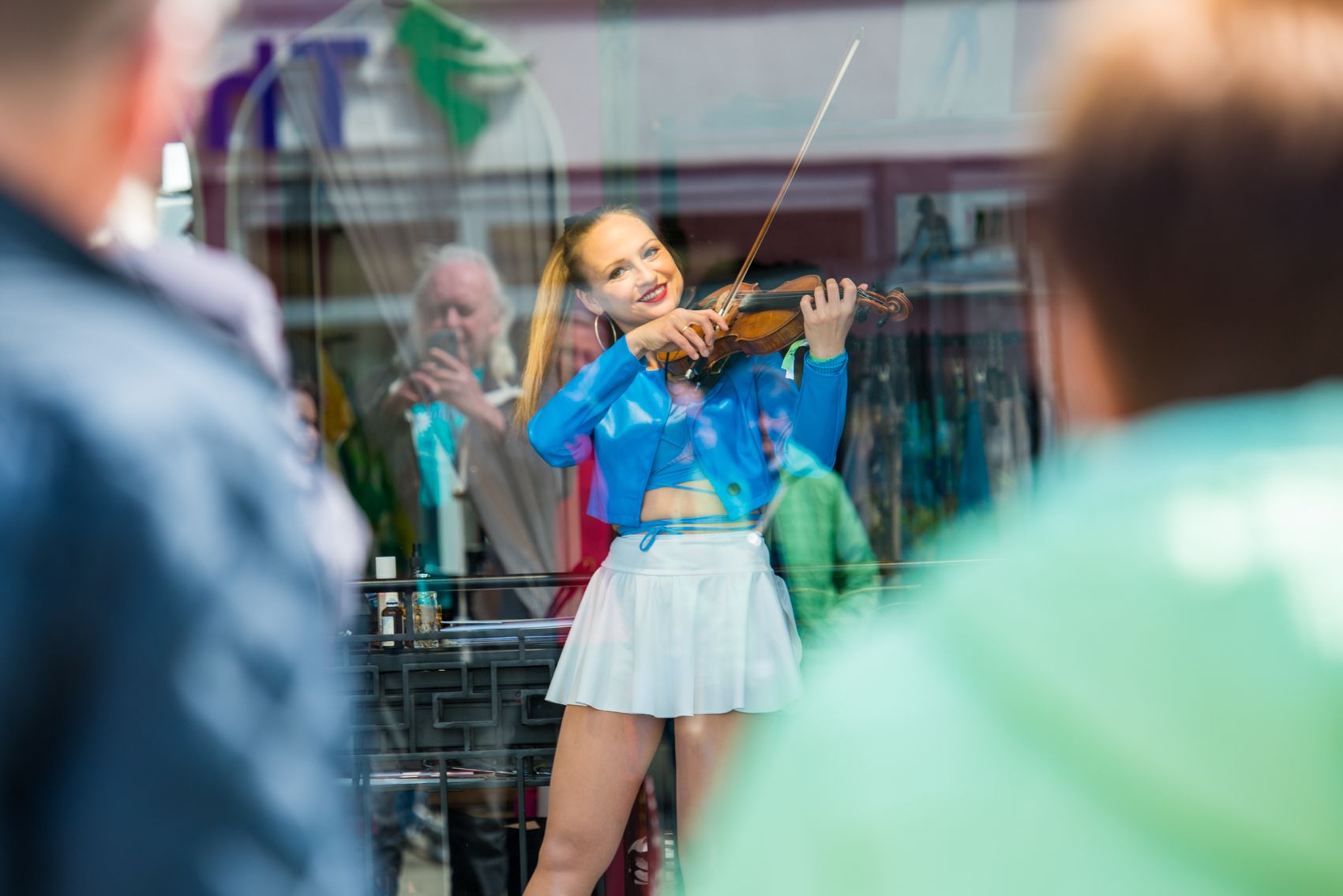 Frau mit Geige hinter Glasscheibe