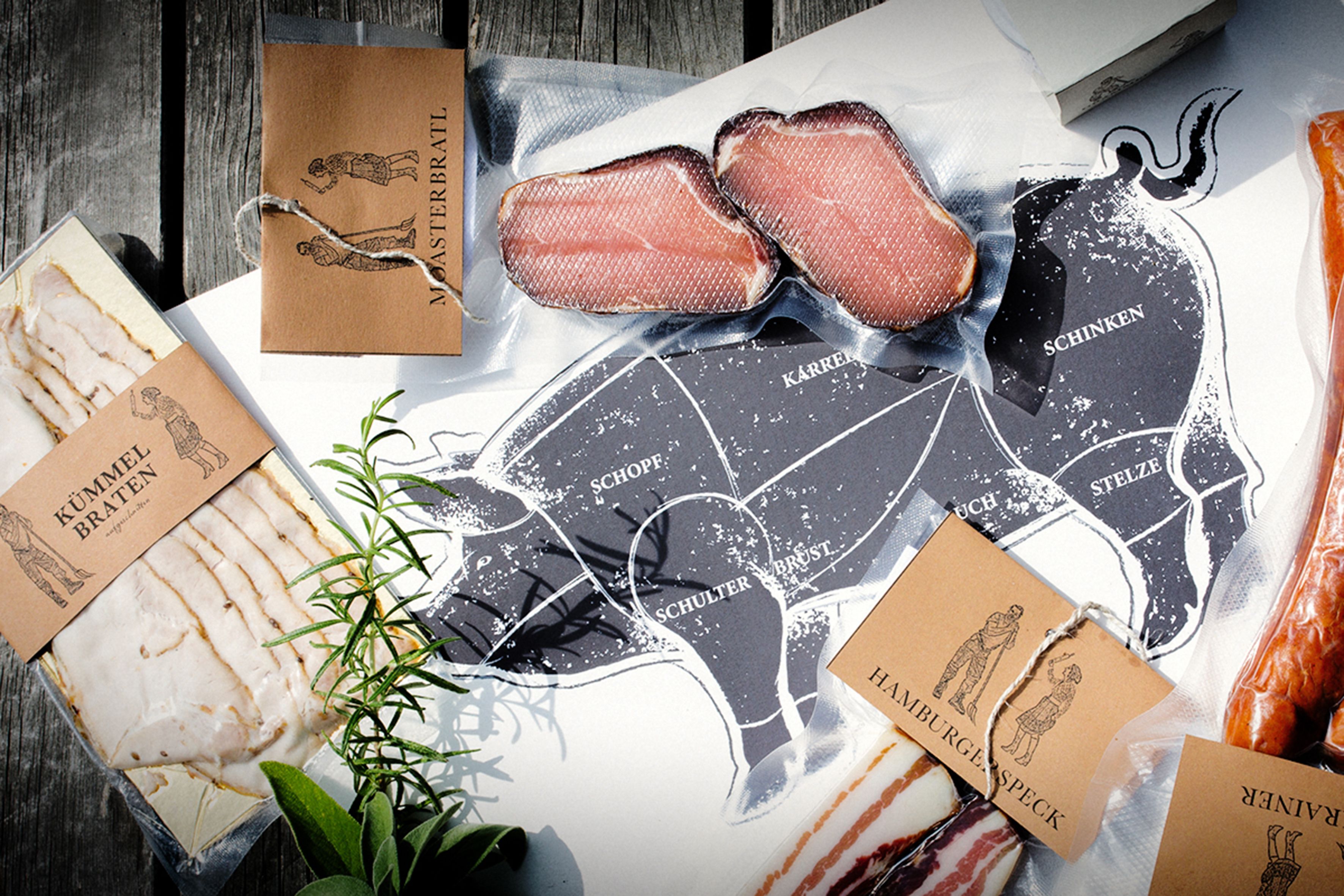 Verschiedene Fleischprodukte mit Etiketten auf einem Tisch, daneben eine Schweinefleisch-Schnittzeichnung.