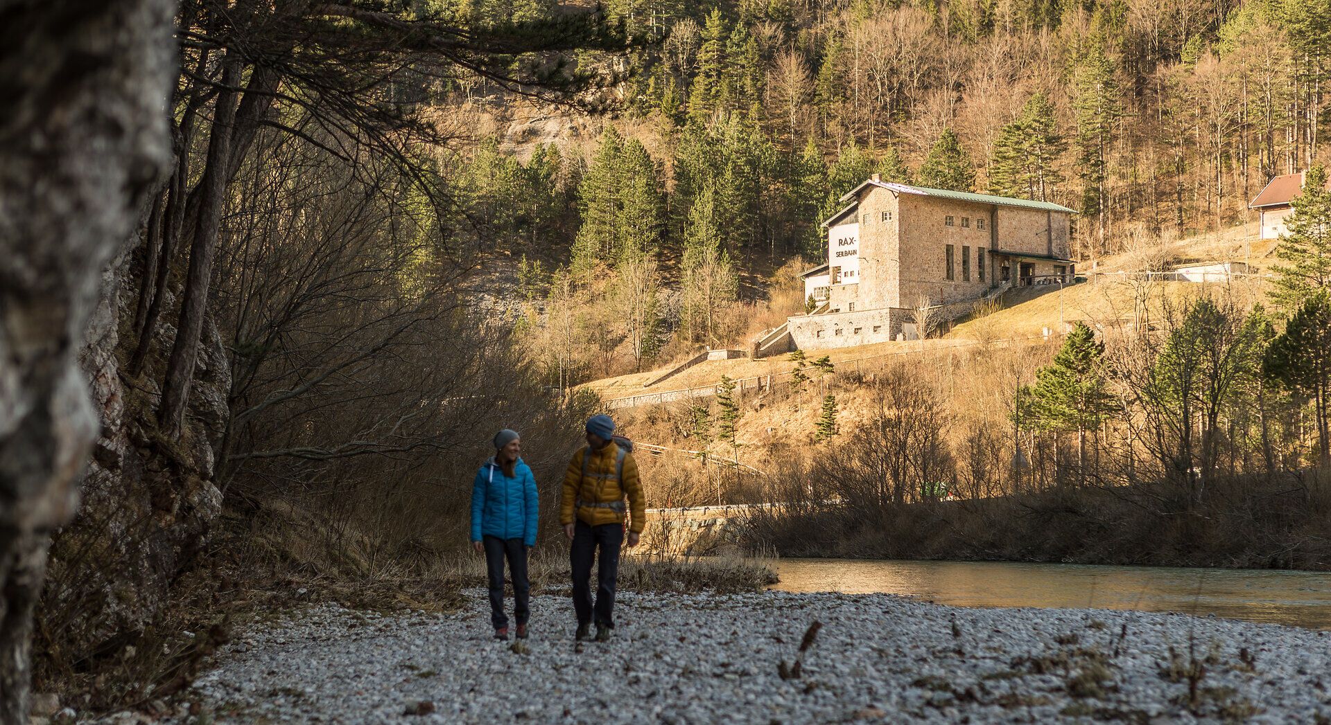 Ein malerischer Spaziergang entlang des glitzernden Wassers, umgeben von majestätischen Bergen und üppigen Wäldern, lädt dazu ein, die frische Bergluft zu genießen. Die sanften Hügel und die beeindruckende Architektur im Hintergrund schaffen eine harmonische Verbindung zwischen Natur und Kultur. Hier wird der Sommer in den Bergen zu einem unvergesslichen Erlebnis.