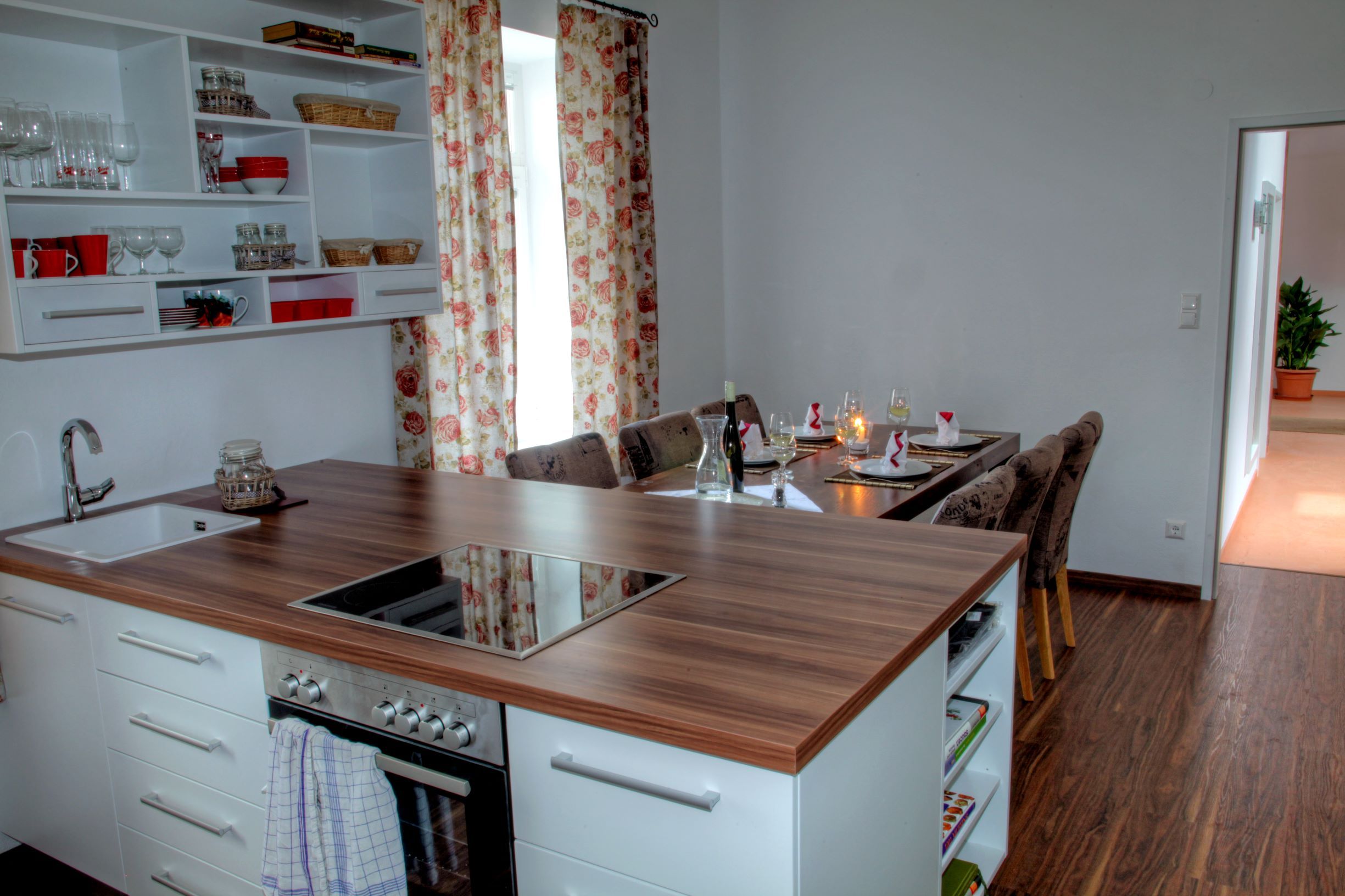 Moderne Küche mit Esstisch in einem Loft, dekoriert mit Blumenmustervorhängen.