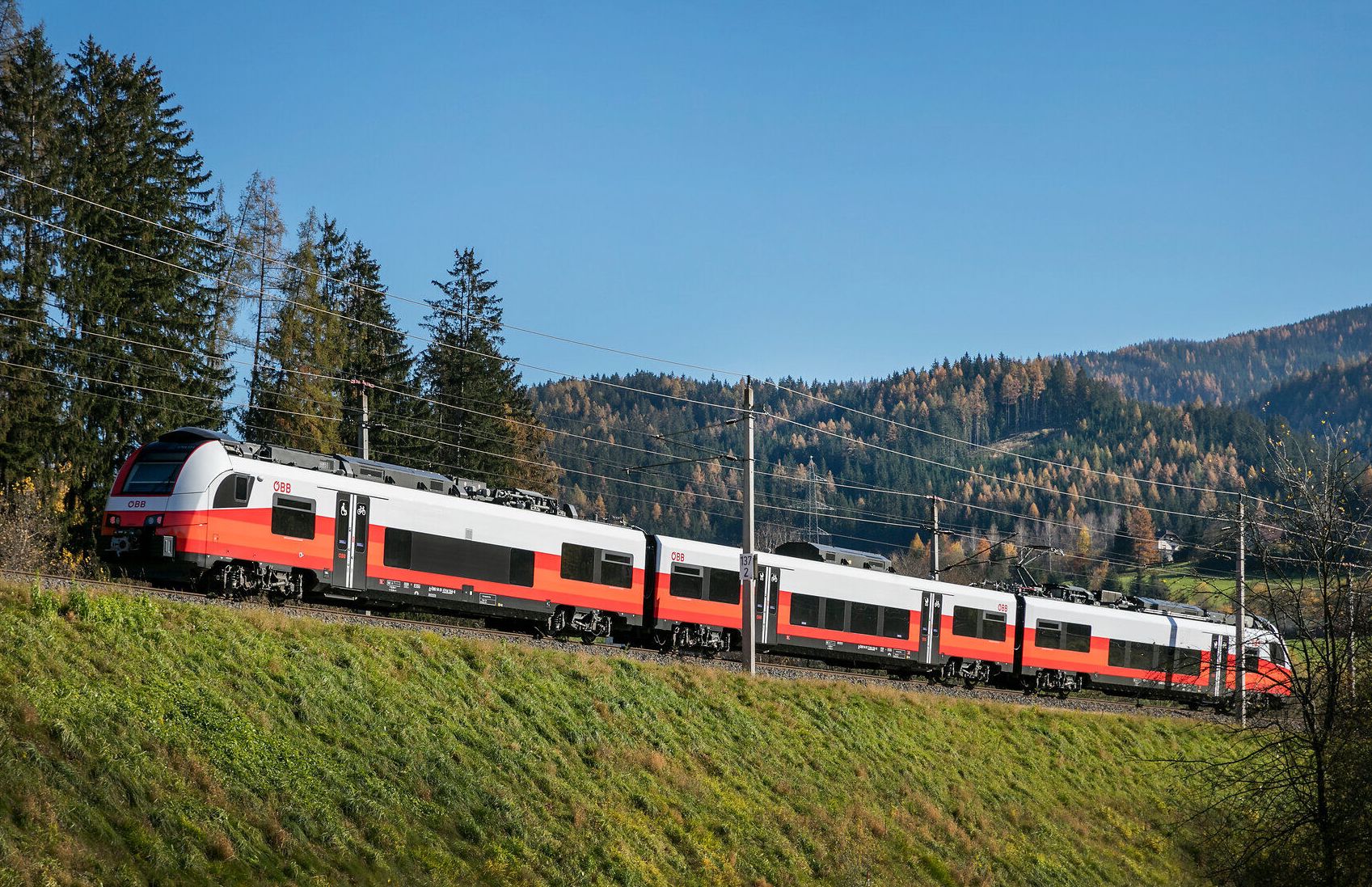 Die sanften Hügel und dichten Wälder ziehen vorbei, während der Zug gemächlich durch die malerische Landschaft fährt. Die klare Luft und die strahlende Sonne laden dazu ein, die Schönheit der Natur zu genießen und die Seele baumeln zu lassen.