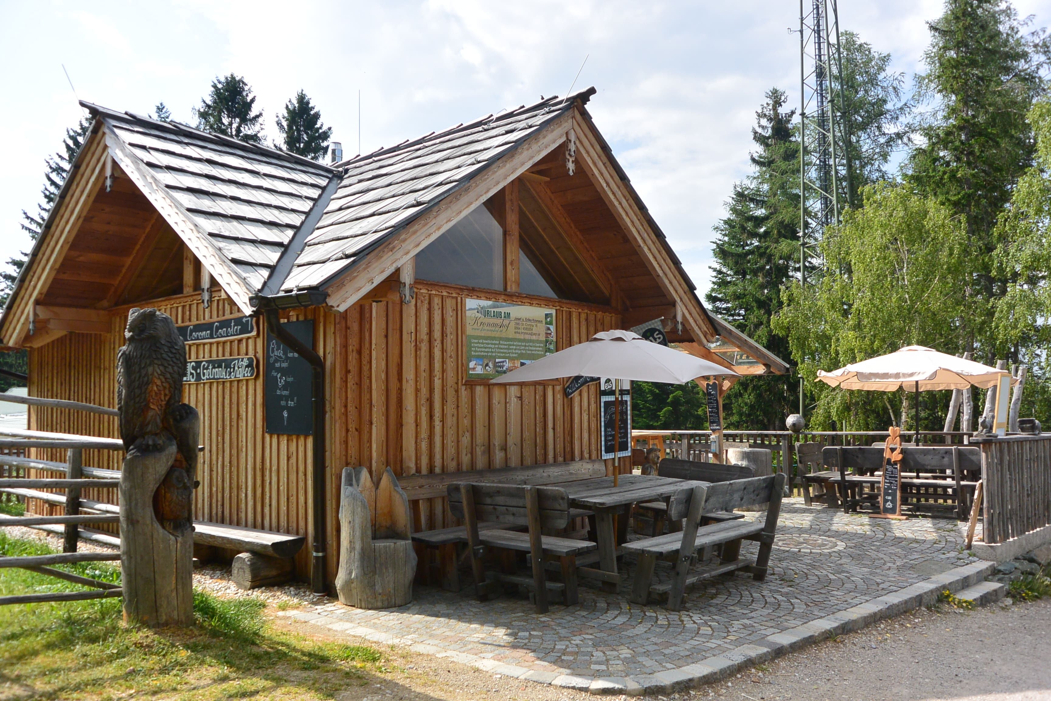 Holzhütte mit Terrasse und Sonnenschirmen im Freien.