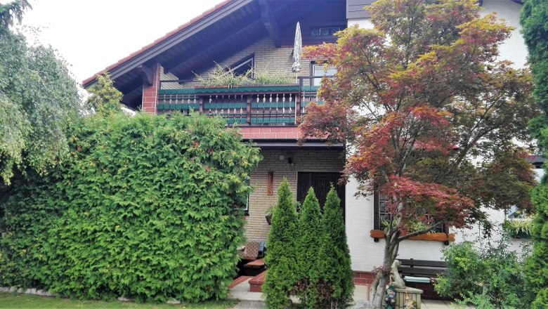 Außenansicht, © Pension Kubicek Außenansicht eines Hauses mit Balkon, umgeben von Bäumen und Sträuchern.