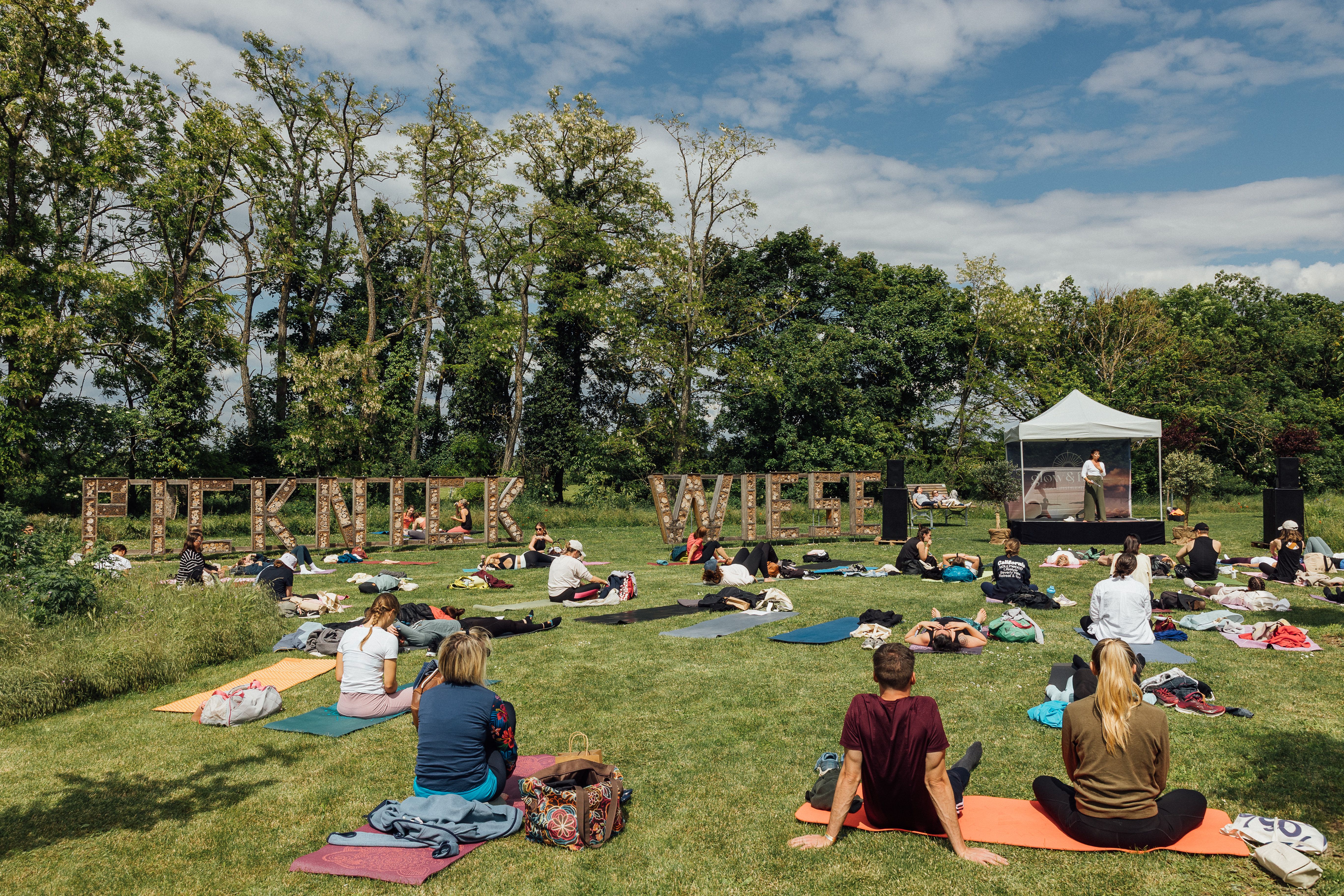 Teilnehmer des Festivals auf der Picknickwiese mit Bühne