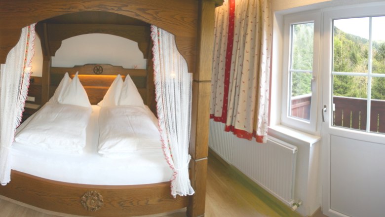 Gemütliches Schlafzimmer mit Himmelbett und Balkonblick ins Grüne.