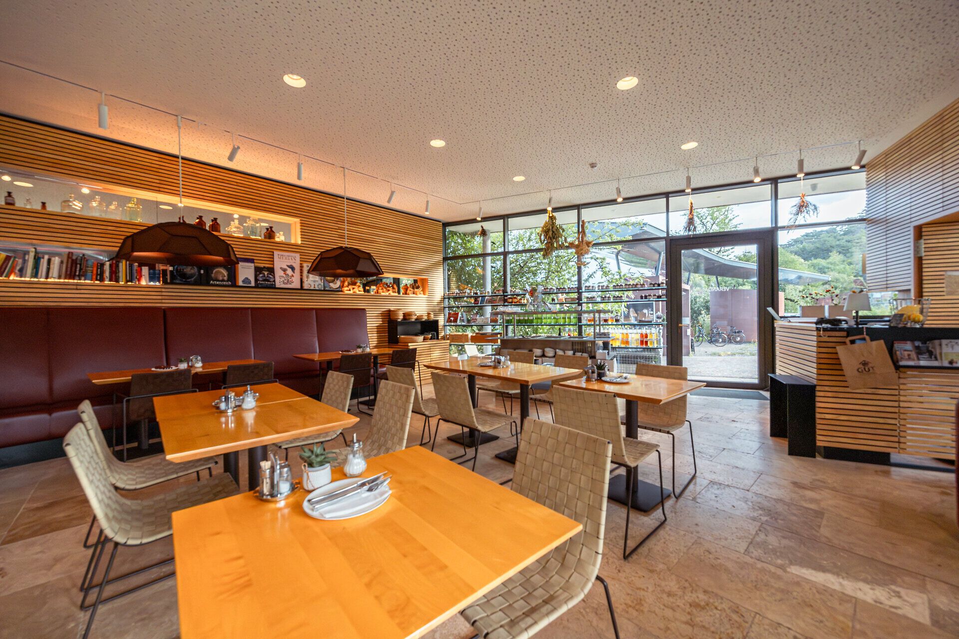 In diesem einladenden Restaurant mit modernem Design und warmen Holztönen genießen Gäste eine entspannte Atmosphäre. Die großen Fenster bieten einen herrlichen Blick auf die umliegende Natur, während die stilvollen Tische und Stühle zum Verweilen einladen. Hier wird der Genuss regionaler Köstlichkeiten zum Erlebnis.