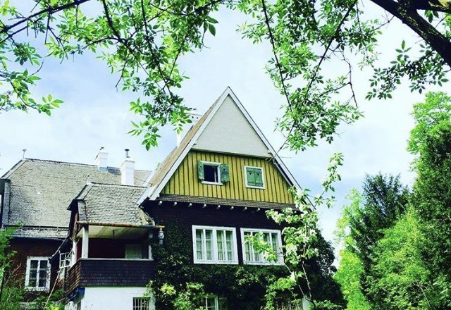 Hausansicht, © Berger Ein traditionelles Haus mit Satteldach, umgeben von grünen Bäumen und Pflanzen.