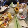 Ein gedeckter Fr&uuml;hst&uuml;ckstisch mit Br&ouml;tchen, Aufschnitt, Eiern, Saft und Kaffee in einer Pension.