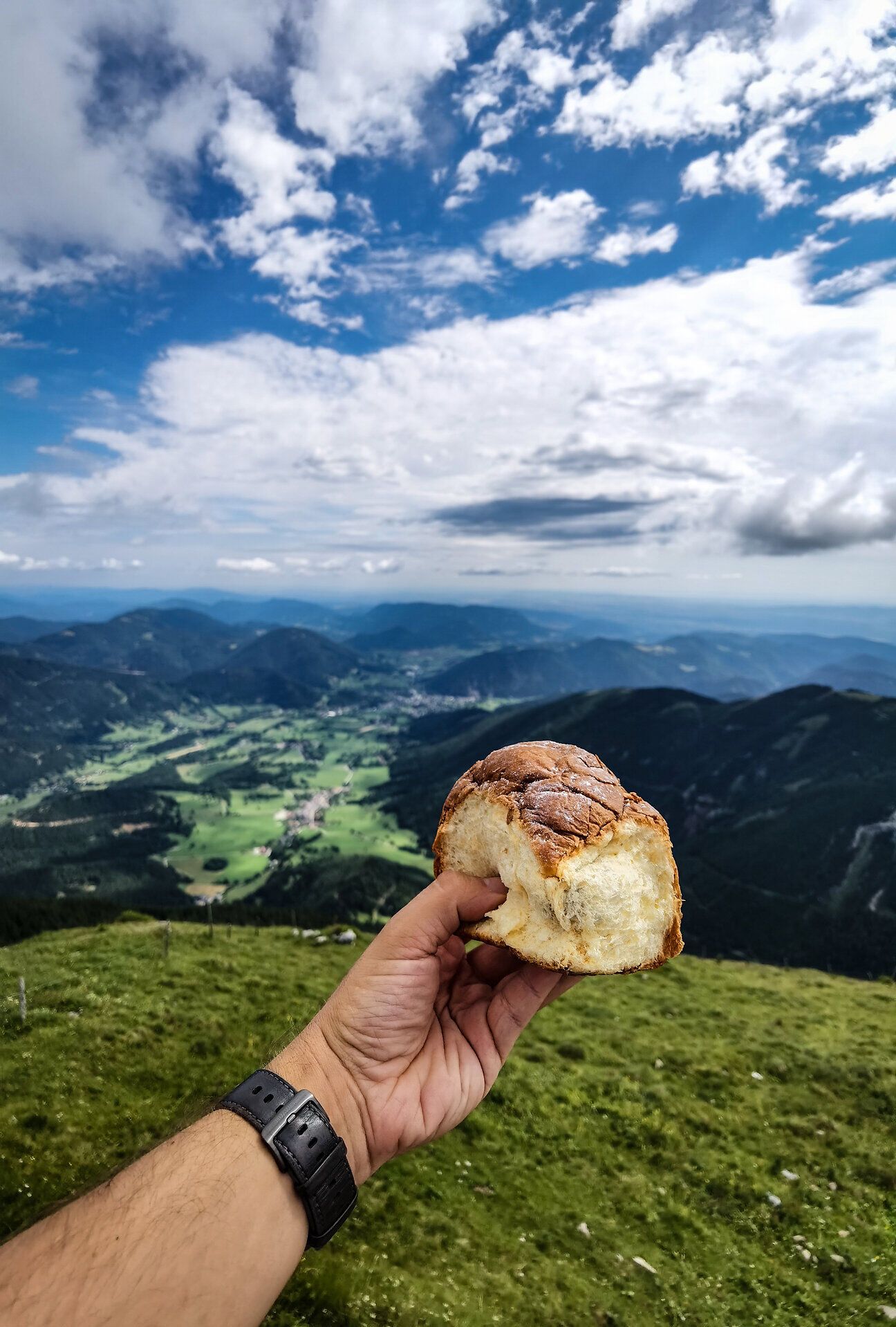 Genießen Sie die atemberaubende Aussicht auf die sanften Hügel und das weite Tal, während Sie ein frisches Stück Brot in der Hand halten. Die frische Bergluft und die majestätische Kulisse der Wiener Alpen schaffen eine unvergessliche Atmosphäre für jeden Wanderer.