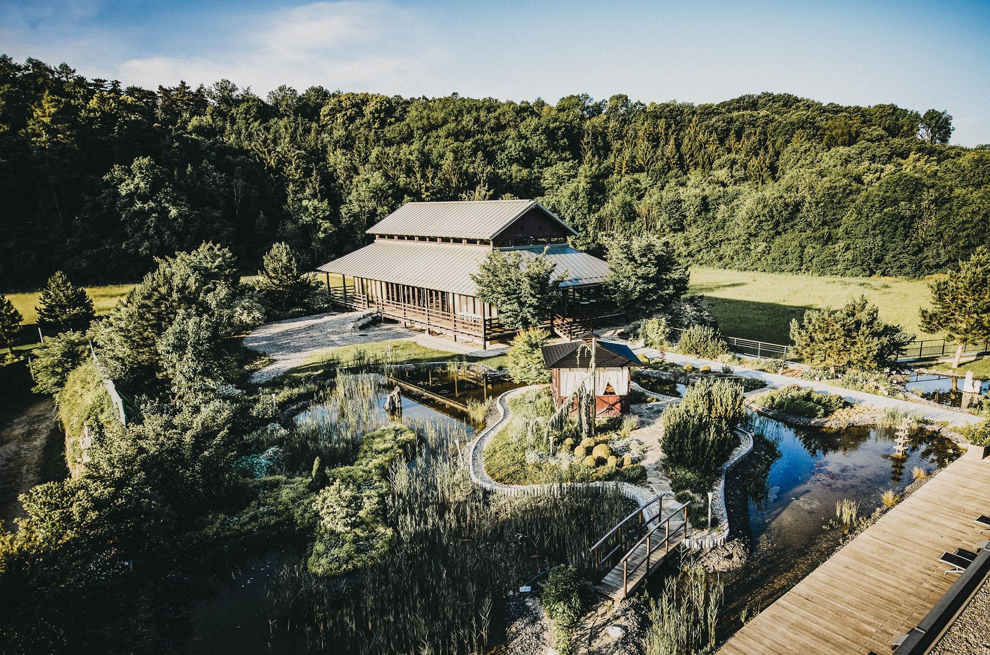 Außenansicht des Linsberg Asia Resorts mit Garten und Teich.