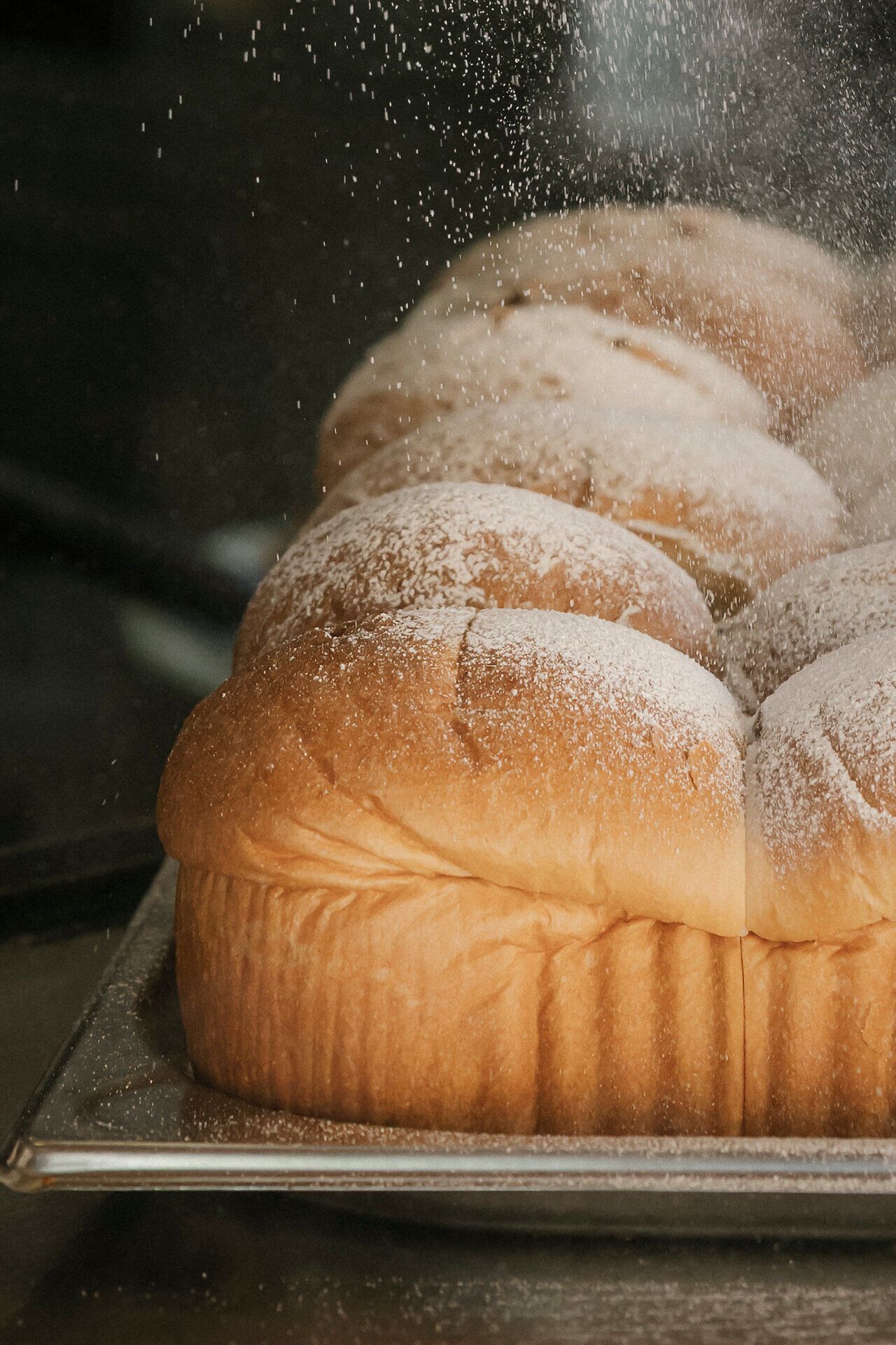 Freshly baked Buchteln dusted with powdered sugar at the Baumgartner bus stop shelter