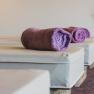 Wellness area with purple towels on loungers.