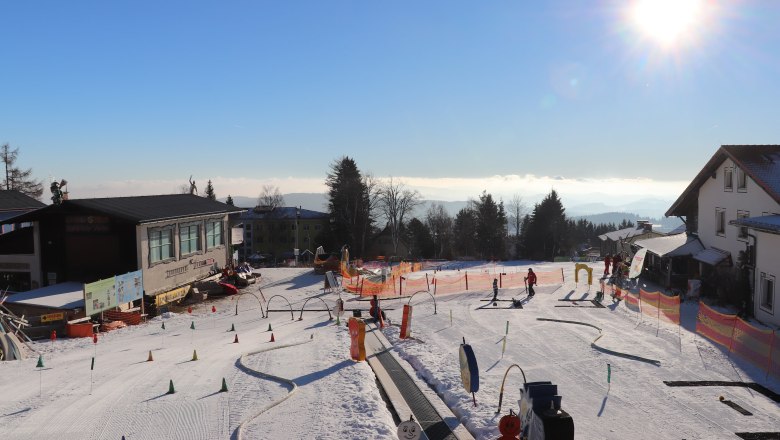 Skischule in Mönichkirchen mit Kindern auf der Piste und Sonnenschein.