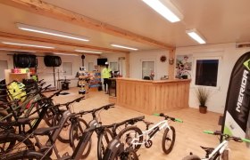 Interior view of a bike rental shop with e-bikes and accessories.