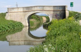 Brücke über den Wiener Neustädter Kanal in Eggendorf mit Graffiti und Spiegelung im Wasser.