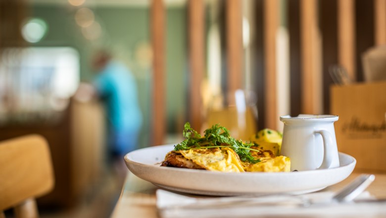 Ein Teller mit Omelett und Kräutern auf einem Tisch in einem Restaurant.