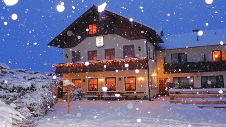 Bauernhof Pyhrahof, © Phyrahof Ein beleuchtetes Bauernhaus im Schnee bei Nacht.