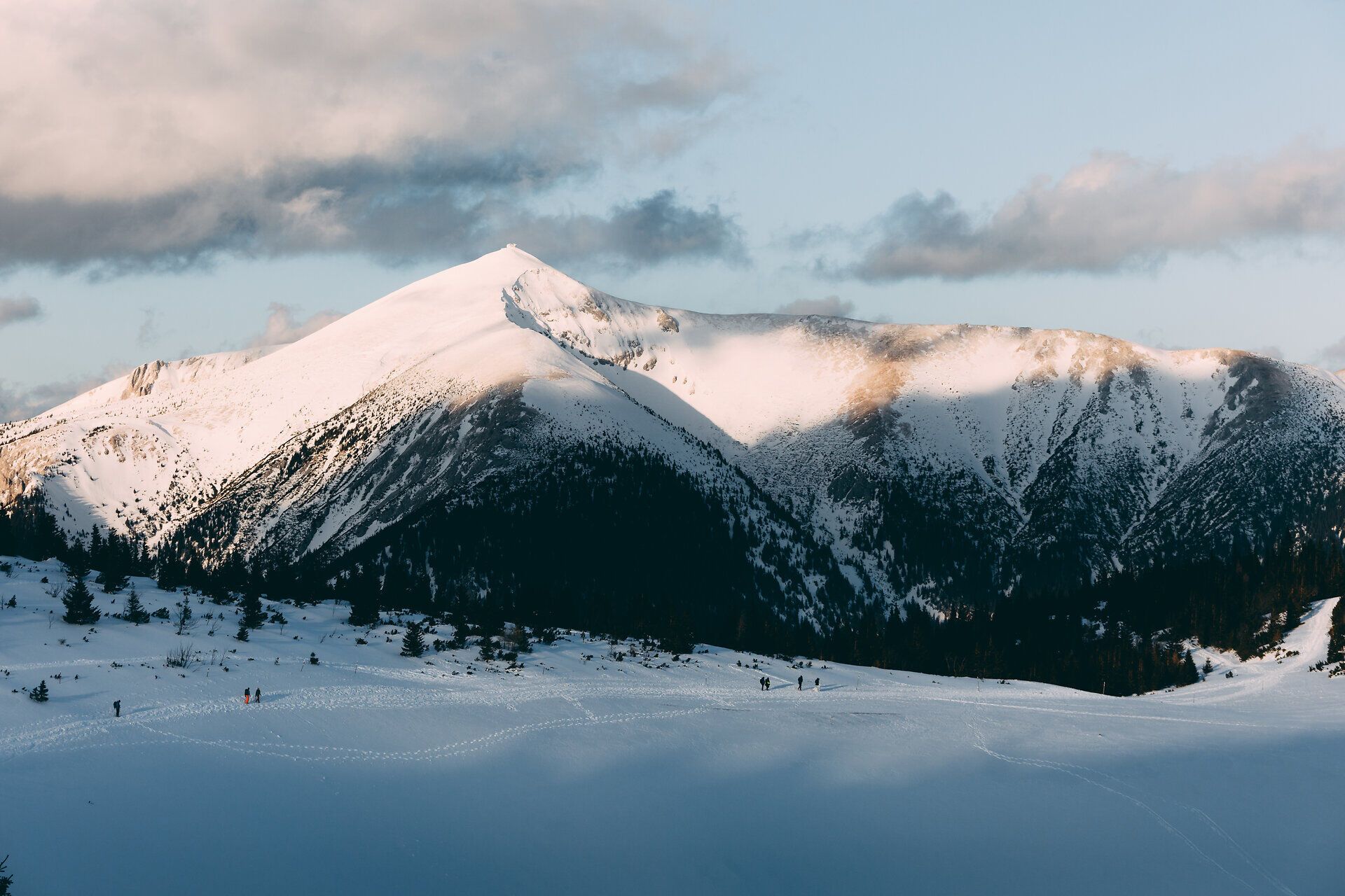 Die schneebedeckten Gipfel der Rax erstrahlen im sanften Licht der Wintersonne und laden zu unvergesslichen Skitouren und Winterwanderungen ein. Die klare, kalte Luft und die unberührte Natur schaffen eine Atmosphäre der Ruhe und Erholung, während die majestätischen Berge im Hintergrund eine beeindruckende Kulisse bieten.