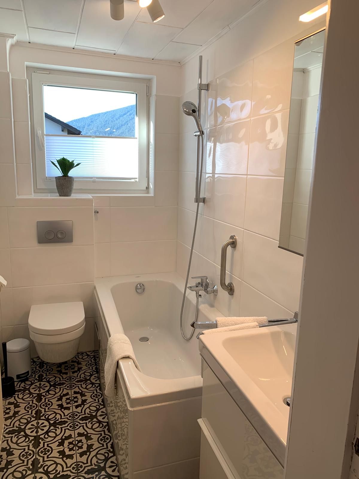 Modernes Badezimmer mit Badewanne, WC und Waschbecken.