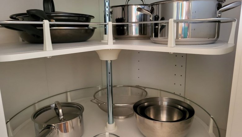 Kitchen cupboard with pots and pans on rotating shelves.