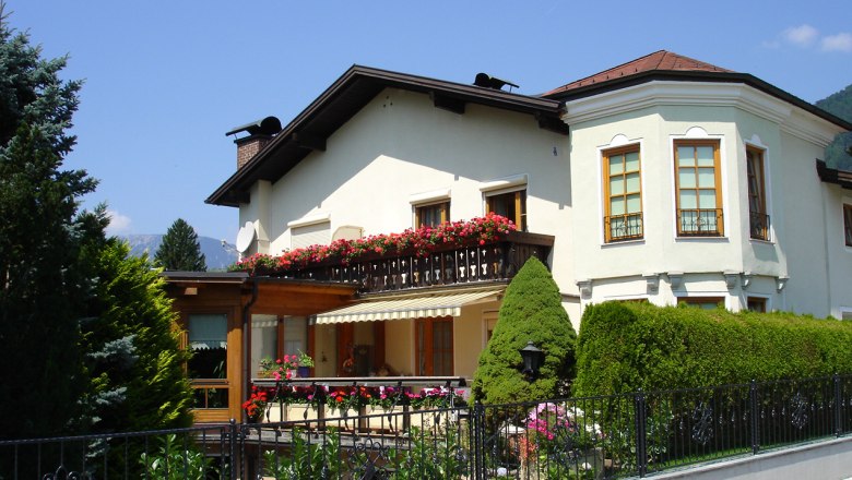 Weißes Haus mit Balkon und Blumen