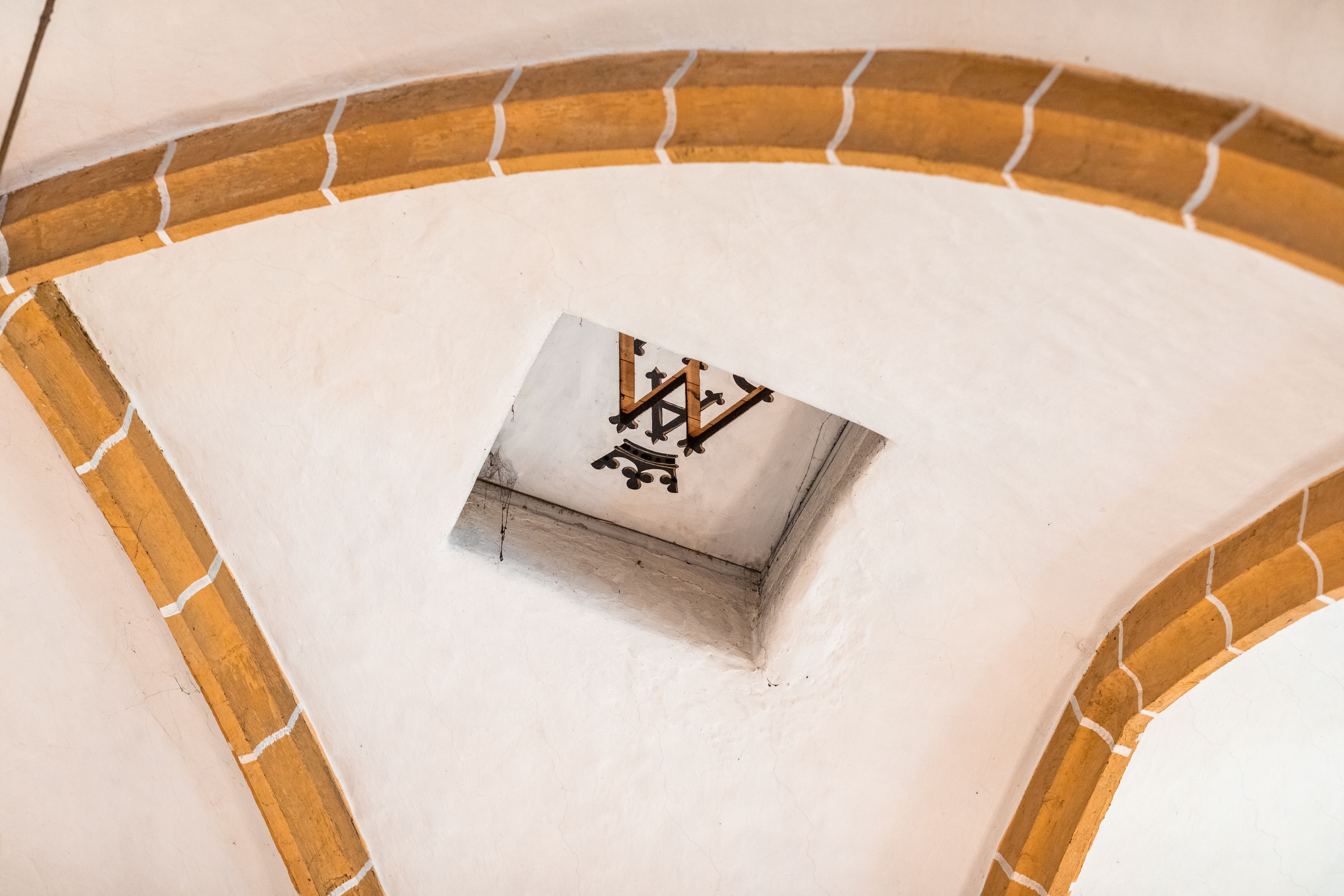 verzierte Steinbögen mit christlichem Schriftsymbol an der Decke der Wehrkirche Edlitz