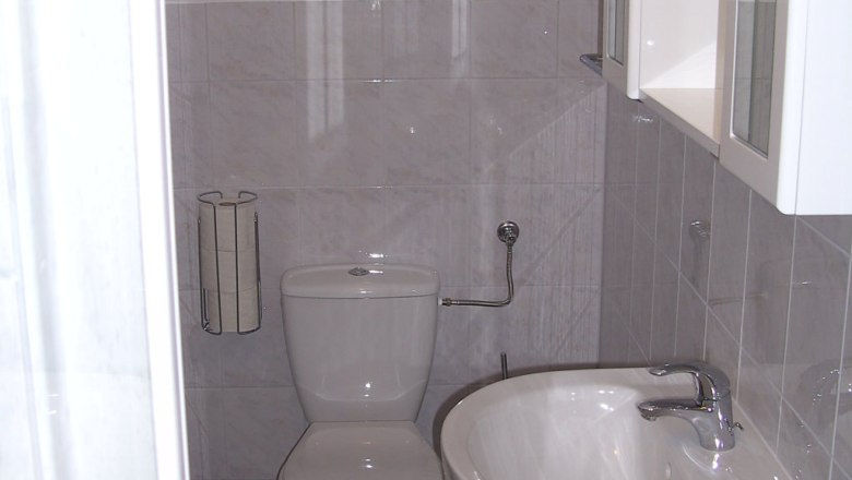 Kleines Badezimmer mit Toilette und Waschbecken.