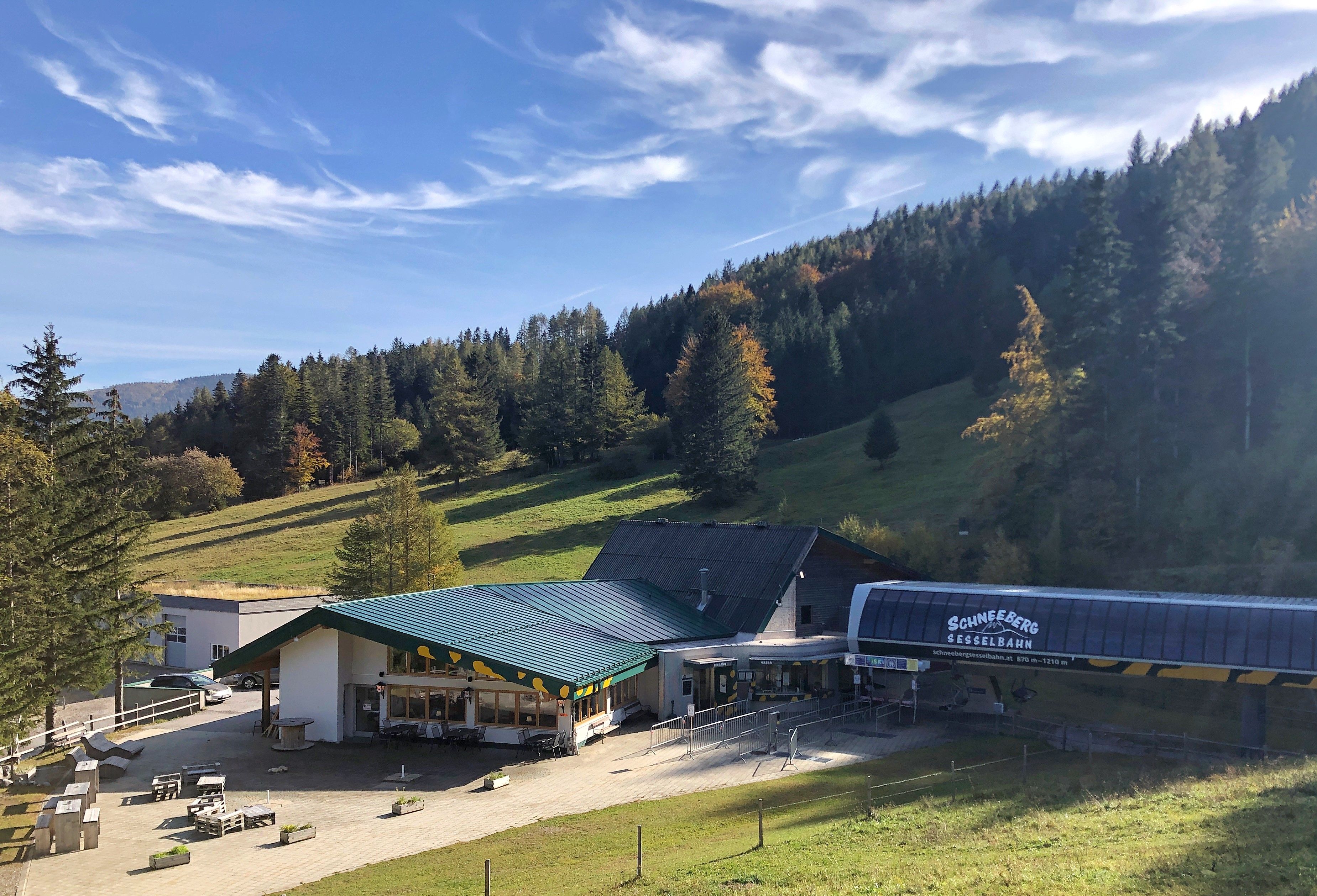 Berglandschaft mit Sesselliftstation und Restaurant im Vordergrund.