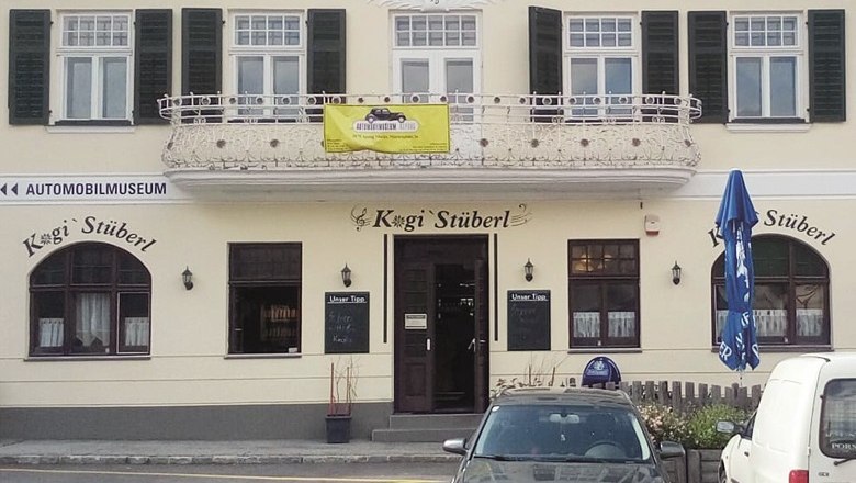 Fassade eines Restaurants namens Kogi Stüberl mit Balkon und geschlossenen Fensterläden.
