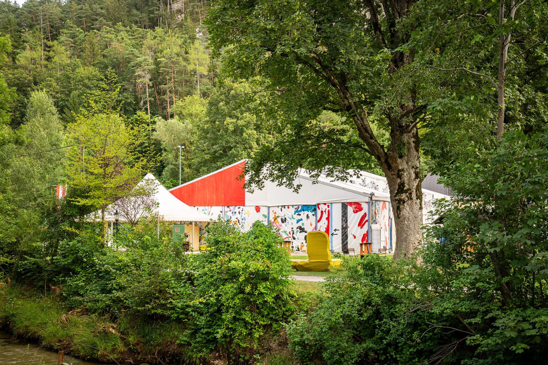 Das Festzelt der Raimundspiele Gutenstein steht in einem kleinen Park. Besucher des Festivals stehen davor.