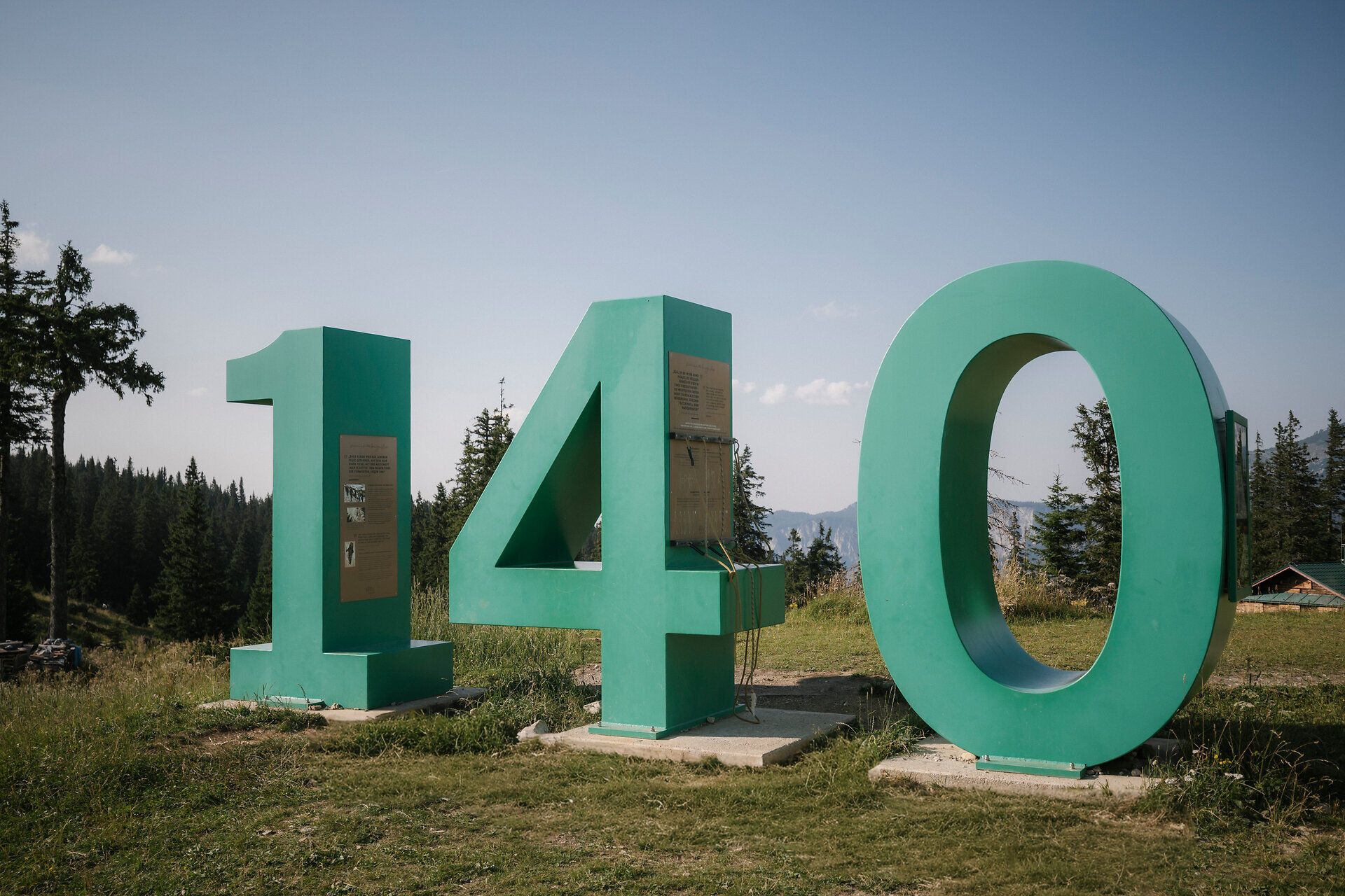 Jubiläums-Zahl "140" als Skulptur vor Bergpanorama beim Raxalm-Berggasthof