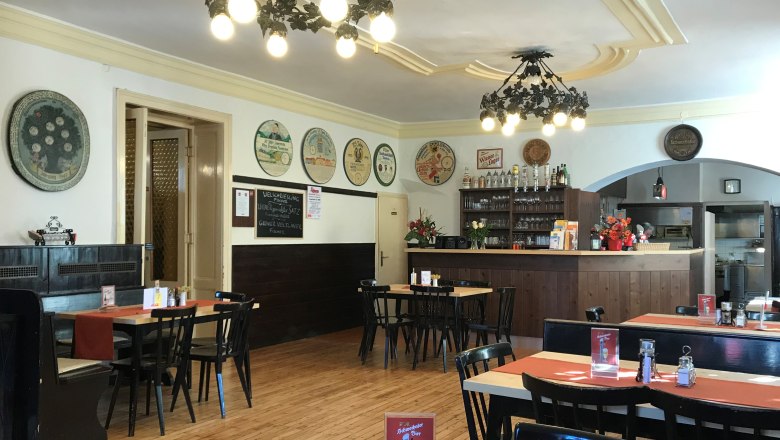 Interior view of a traditional brewery with wooden furniture and decorative wall plates.