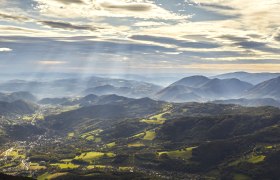 Panoramablick auf die Raxalpen mit Sonnenstrahlen und Wolken am Himmel.