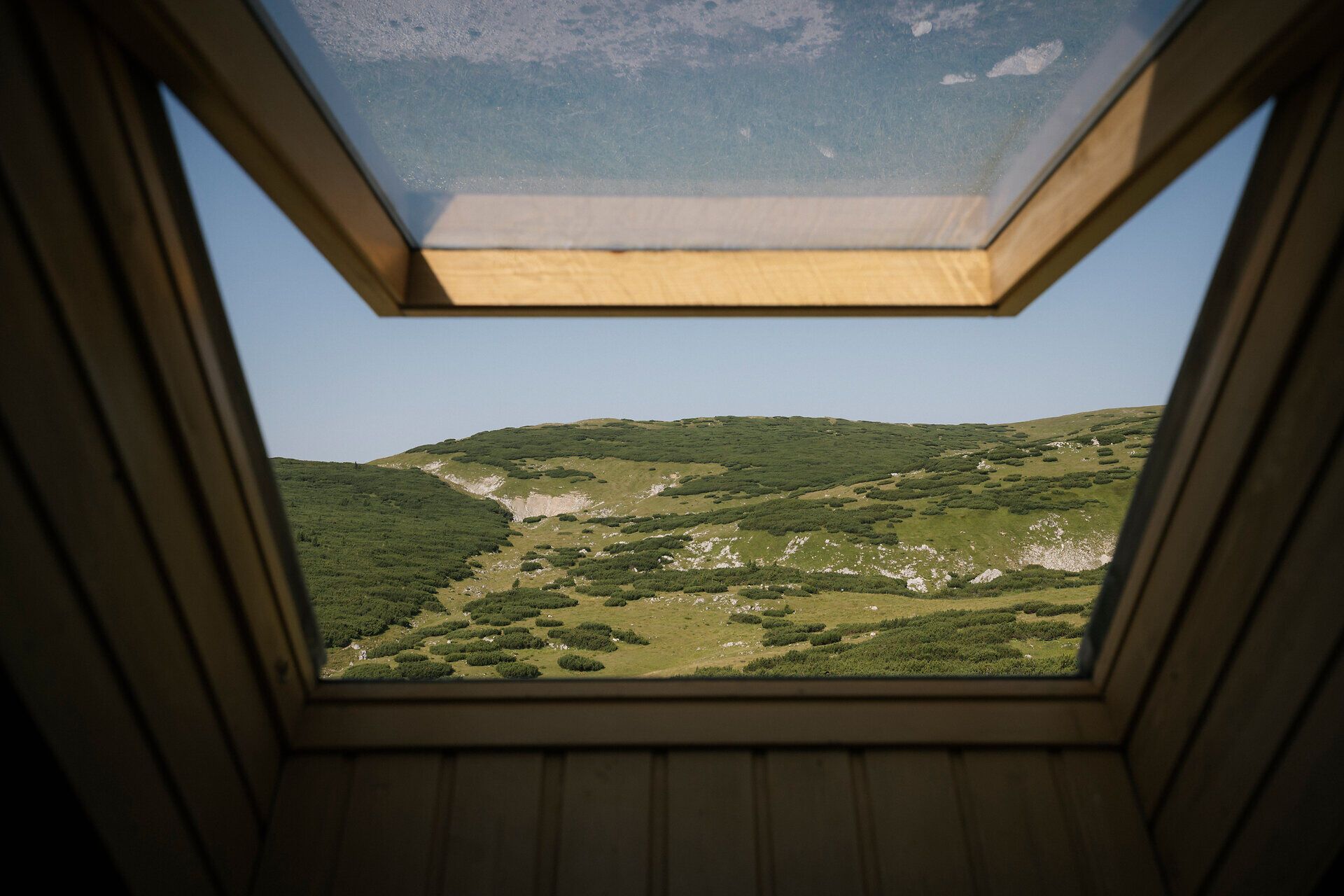 Ausblick durch ein Dachfenster auf die Berglandschaft beim Damböckhaus am Schneeberg
