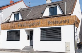 Fassade eines Restaurants mit dem Namen Piestingerhof, dekoriert mit Lichterketten.