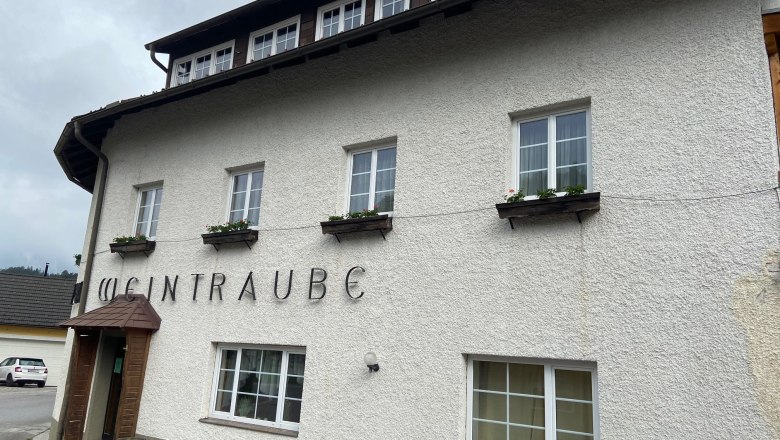 Fassade eines Gebäudes mit dem Schriftzug 'Weintraube'.