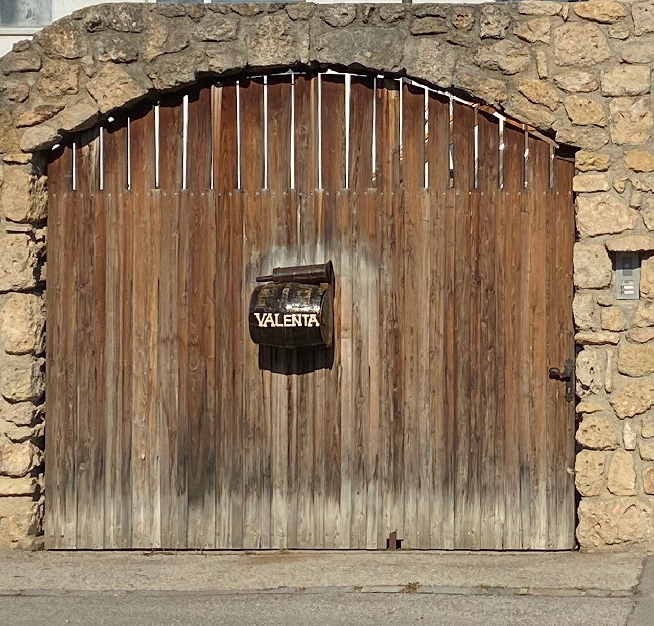 Holztor mit Briefkasten und Aufschrift 'Valenta'.