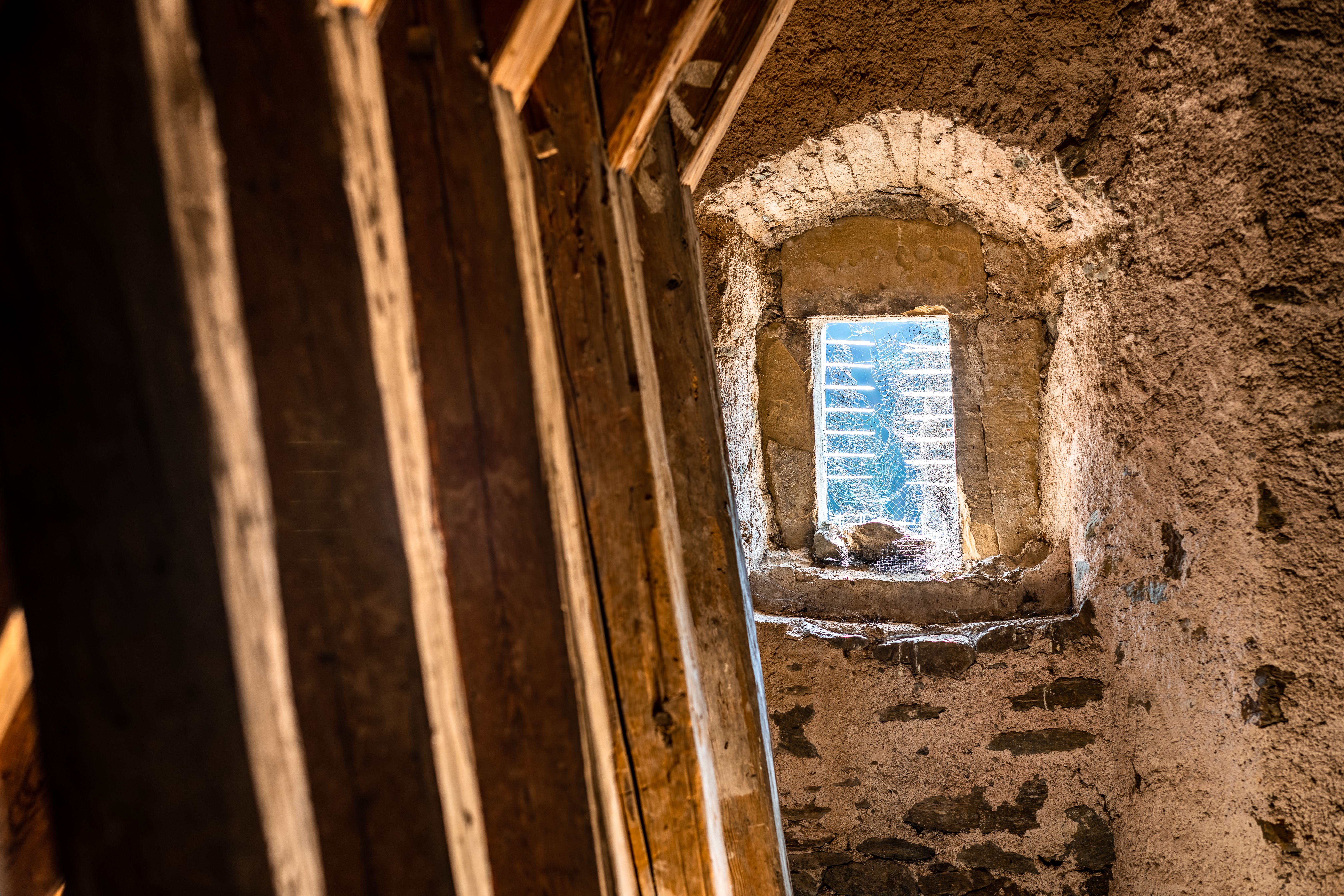 Hölzerne Balken, Steinmauer und Fensteröffnung in der Steinmauer am Dachgeschoss der Wehrkirche Edlitz