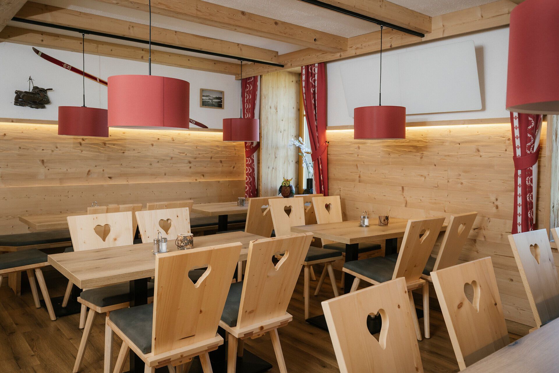 Gastraum mit Holztischen und Stühlen mit Herzmotiv im Damböckhaus am Schneeberg