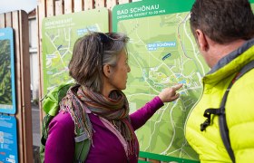 Zwei Personen betrachten eine Wanderkarte von Bad Schönau.